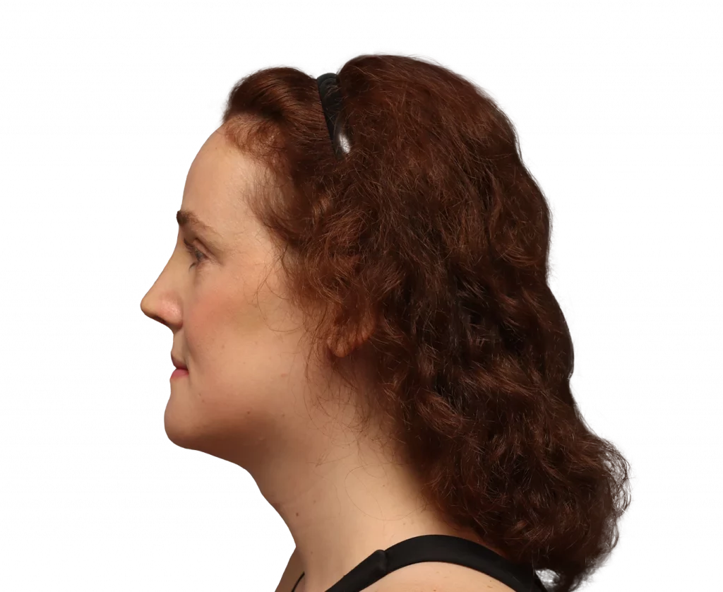 Profile view of a woman with auburn curly hair, wearing a black top and sunglasses resting on her head, facing left.