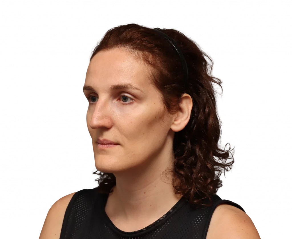 Portrait of a woman with brown hair pulled back by a black headband, facing left, wearing a black sleeveless top.