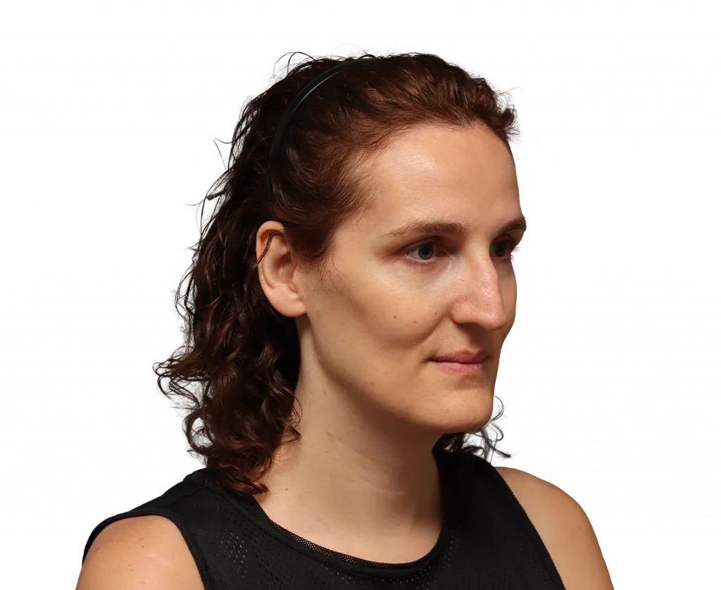 Profile-view portrait of a woman with dark curly hair held by a thin headband, wearing a black sleeveless top.