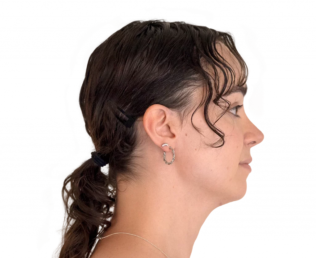 Profile view of a woman facing right with dark hair in a low ponytail, wearing a hoop earring and a delicate necklace.
