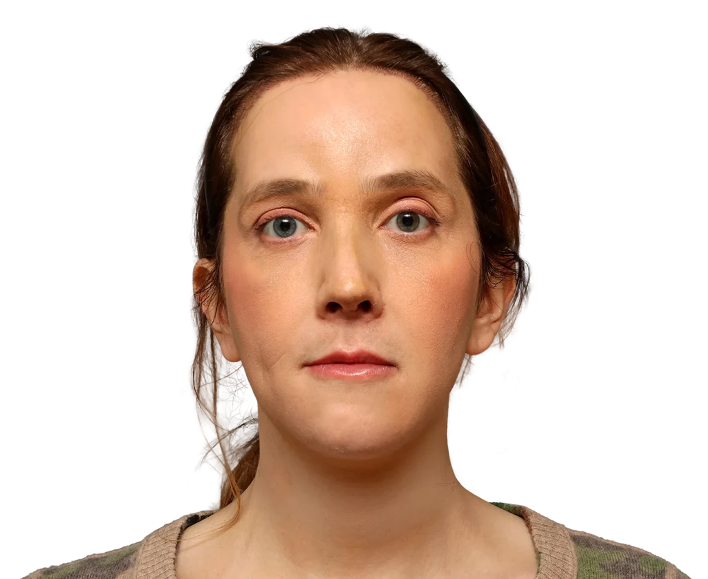 Portrait of a woman with light brown hair and blue eyes, facing the camera with a neutral expression against a dark background