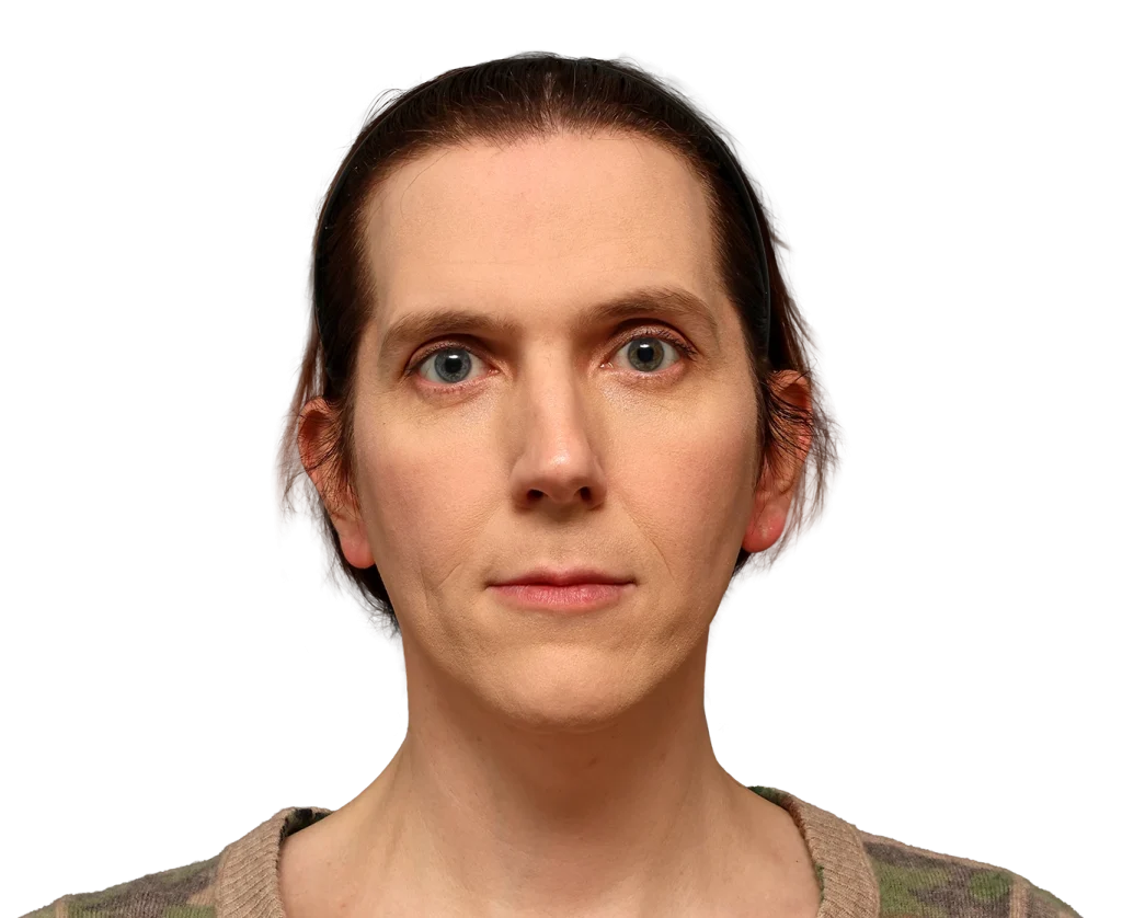Close-up portrait of a woman with light skin, brown hair in a headband, and neutral expression against a black background.