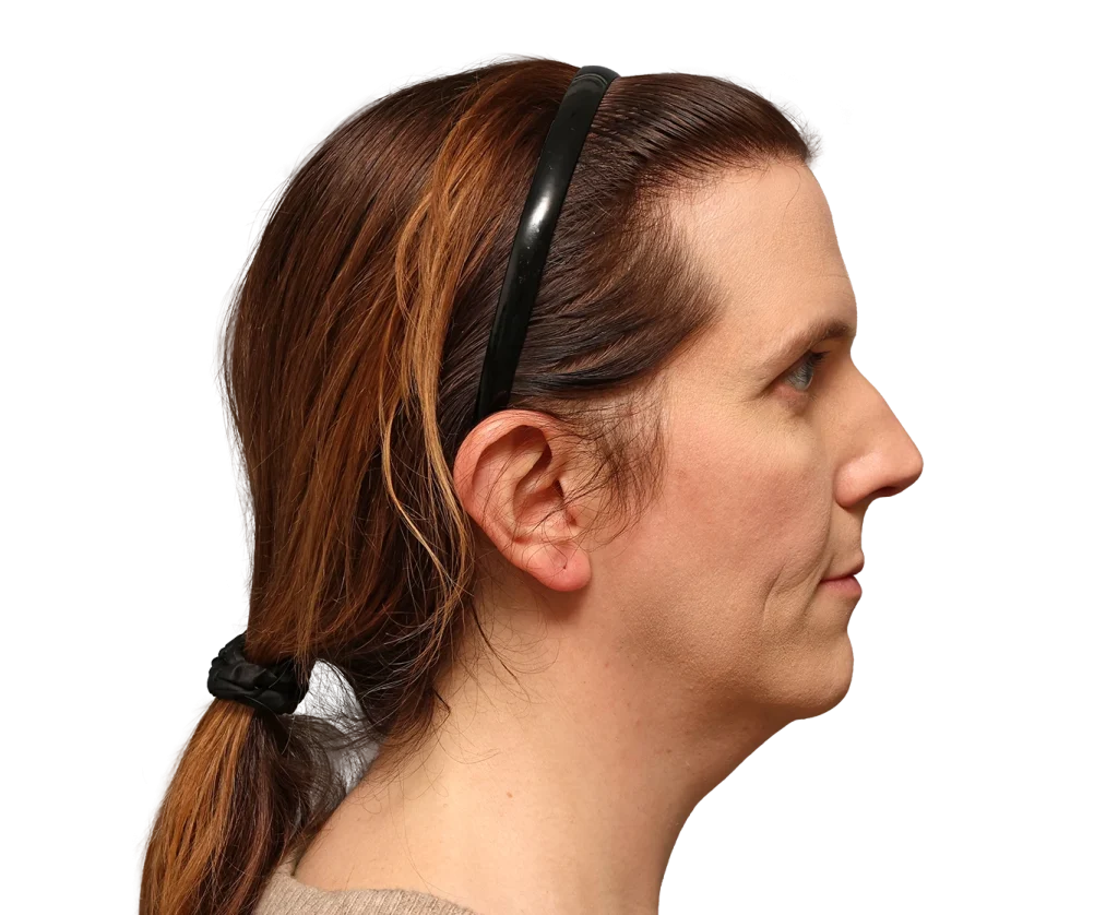 Profile view of a woman with brown hair tied in a low ponytail and a black headband, facing right.