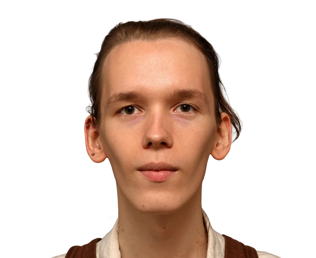 Close-up portrait of a young person with fair skin and light brown hair, looking straight ahead with a neutral expression on a black background, head and shoulders visible.